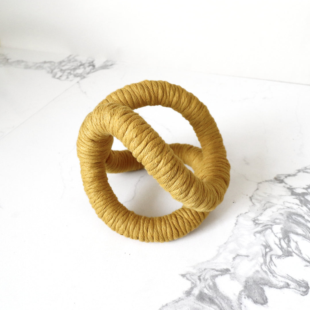  console table decor in mustard showcasing infinity knot made with one continuous jute rope and wrapped with cotton. Perfect for gift for graduation.