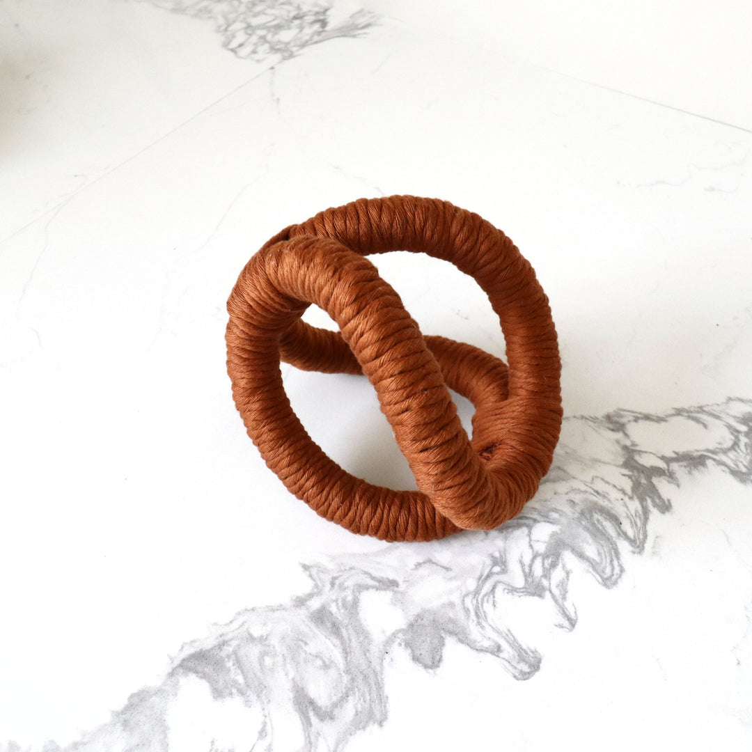 Rope knot art, a modern home accessory in Terracotta color. A bold, three-dimensional abstract rope sculpture, is handmade with one continuous piece of rope for table and shelf decor.