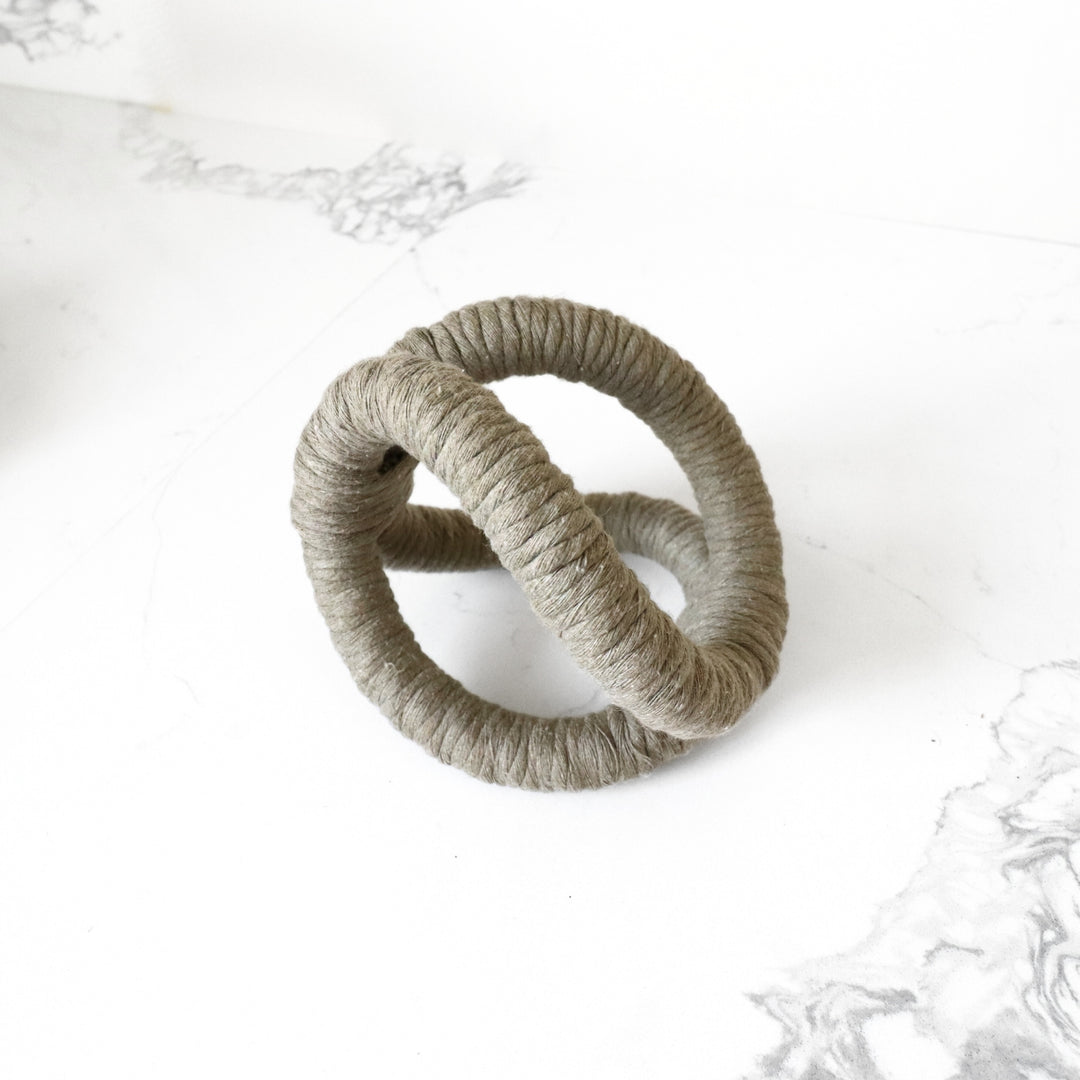 Jute rope Desk accessory sculpture in sage showcasing infinity knot made with one continuous jute rope and wrapped with cotton.