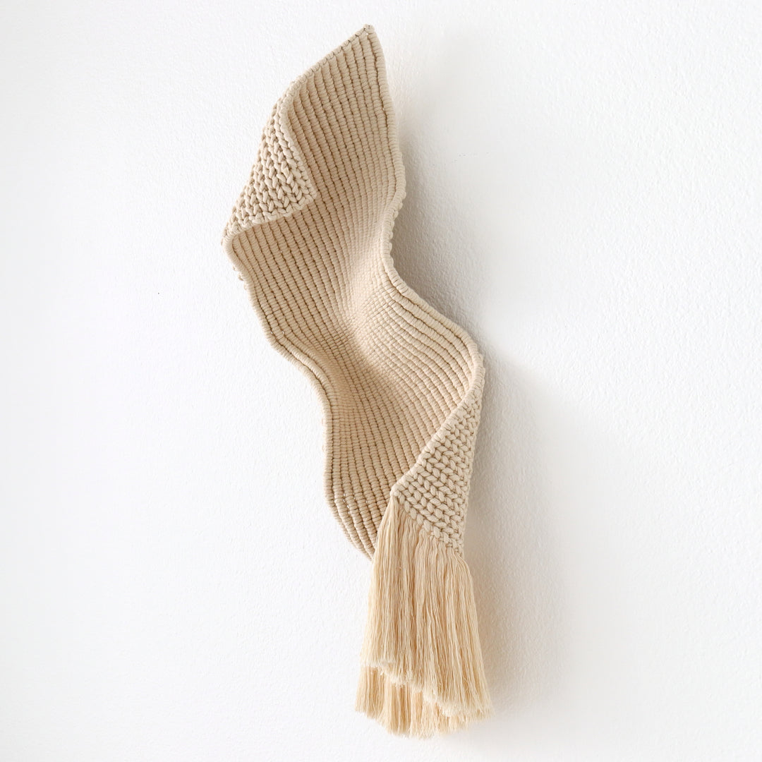 A handwoven cotton wall sculpture with soft flowing curves, ideal for gallery exhibitions and curated interiors.