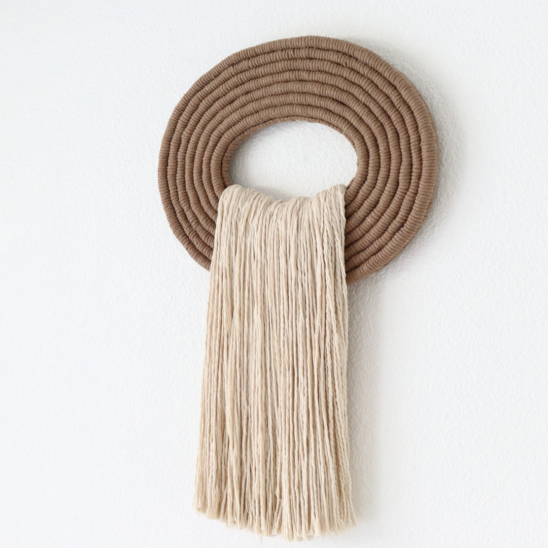 Elegant white wall hanging tassel with a distinctive beige circular accent for a modern decorative touch with Contemporary Wall hangings