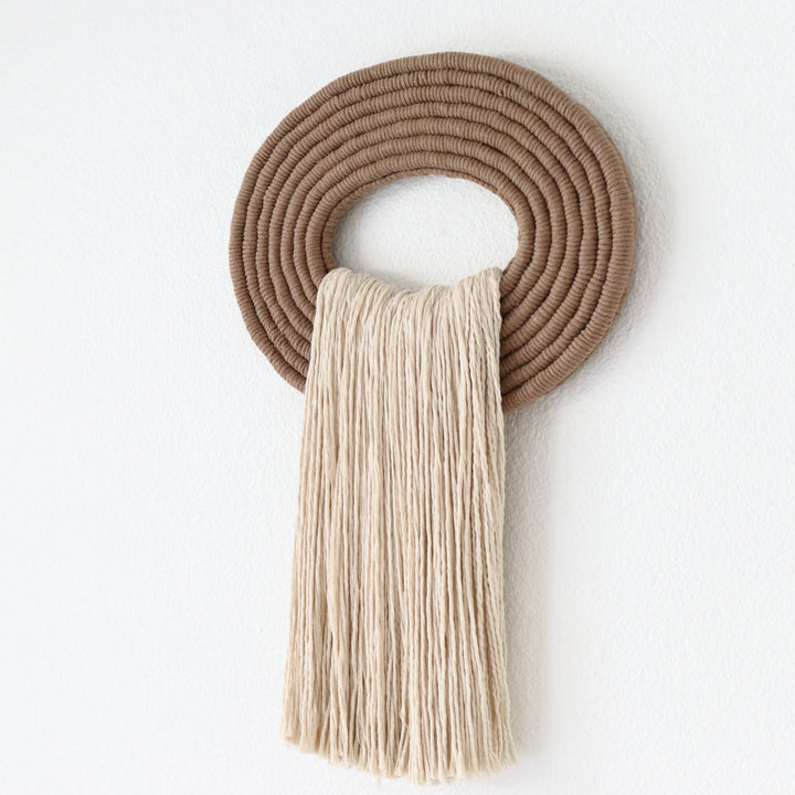 Elegant white wall hanging tassel with a distinctive beige circular accent for a modern decorative touch with Contemporary Wall hangings