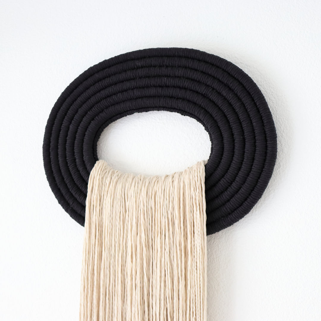 Elegant beige wall hanging tassel with a distinctive black circular accent for a modern decorative touch with Contemporary Wall hangings