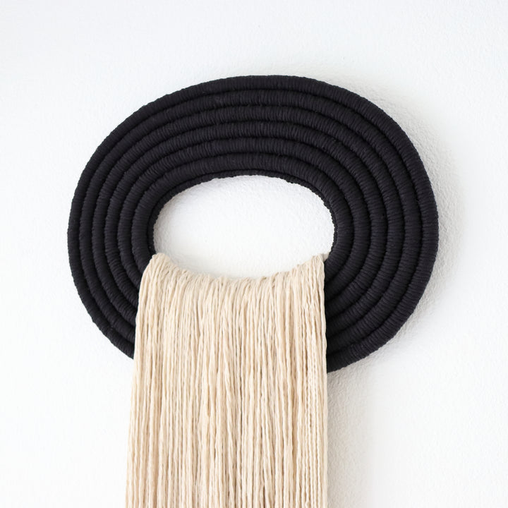 Elegant beige wall hanging tassel with a distinctive black circular accent for a modern decorative touch with Contemporary Wall hangings