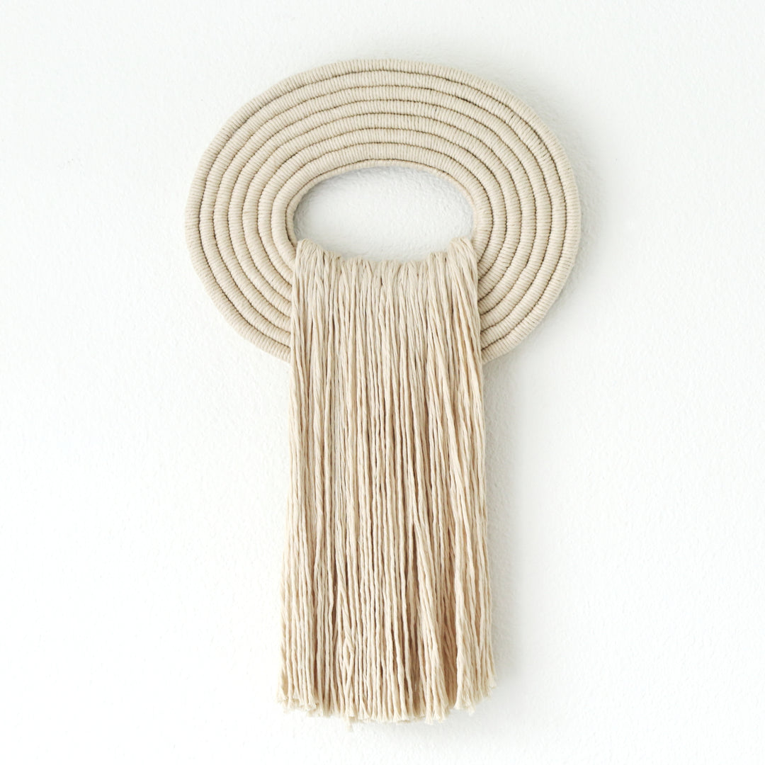 Elegant beige wall hanging tassel with a distinctive white circular accent for a modern decorative touch with Contemporary Wall hangings