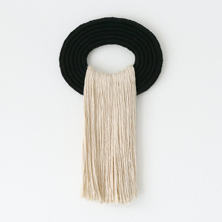 Elegant beige wall hanging tassel with a distinctive black circular accent for a modern decorative touch with Contemporary Wall hangings