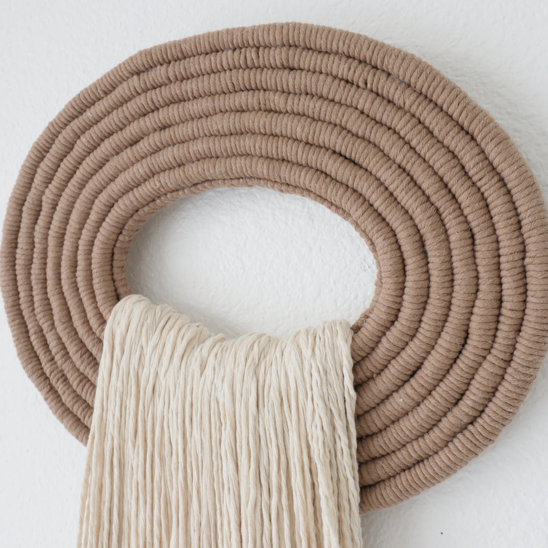 Elegant white wall hanging tassel with a distinctive beige circular accent for a modern decorative touch with Contemporary Wall hangings