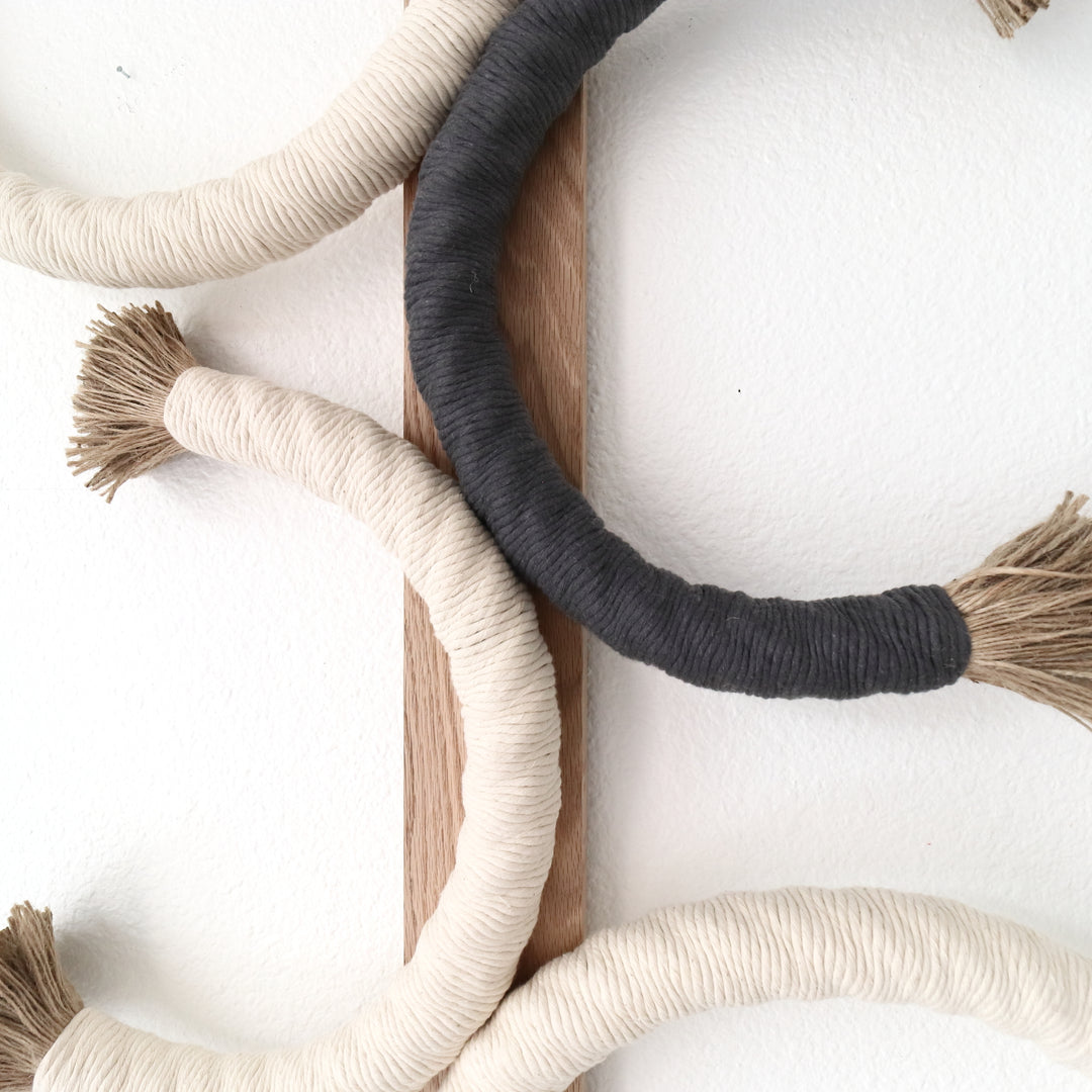 Artistic rope sculpture featuring interlaced circles with contrasting tassel accents, mounted on wood for a minimalist aesthetic, Unique Fiber Art, Earthy Tones, Jute Artworks - Coastal Farm House, Cottage Style, Eco-friendly living, Neutral Decor