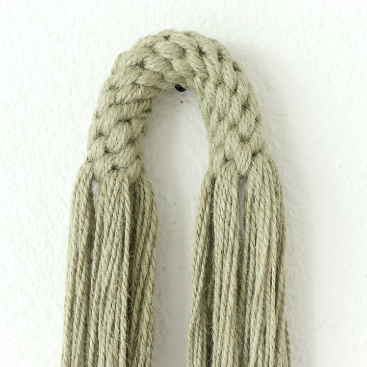 Small hemp tassel in sage green, a handcrafted Natural Dimensional Wall Art by Yashi Designs, minimalistic and modern wall hanging.