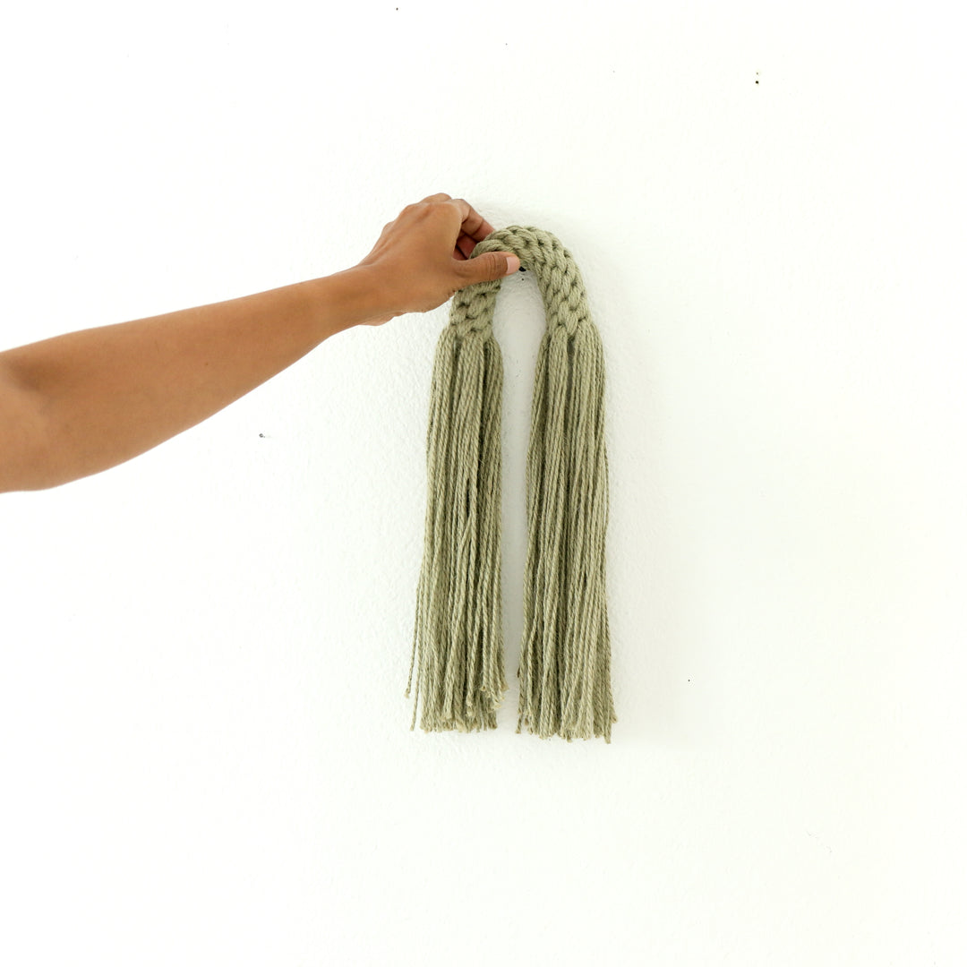 Small hemp tassel in sage green, a handcrafted Natural Dimensional Wall Art by Yashi Designs, minimalistic and modern wall hanging.