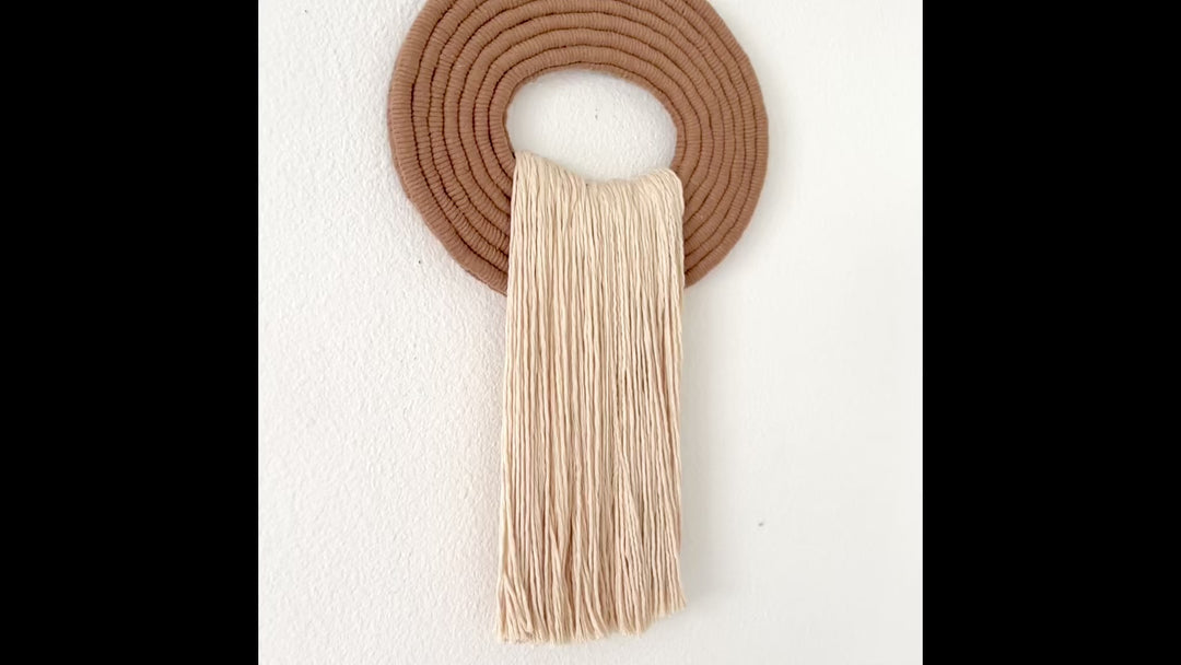 Elegant white wall hanging tassel with a distinctive beige circular accent for a modern decorative touch with Contemporary Wall hangings