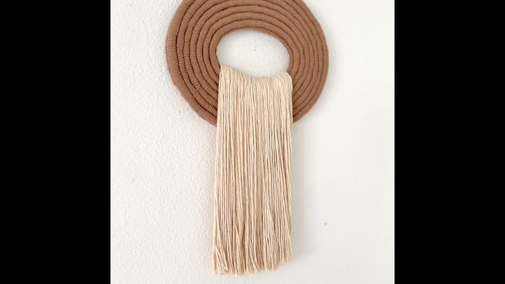 Elegant white wall hanging tassel with a distinctive beige circular accent for a modern decorative touch with Contemporary Wall hangings
