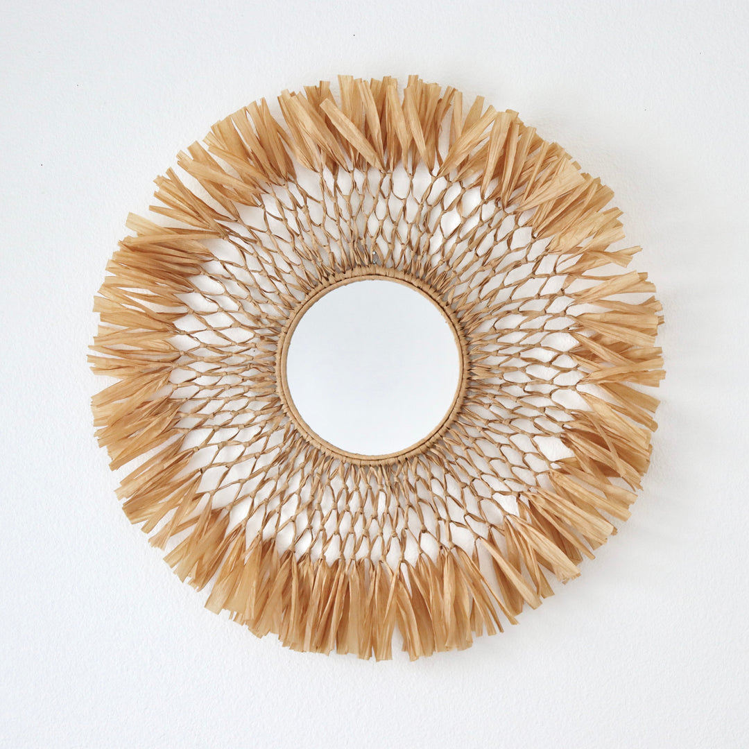 Handcrafted macrame raffia fiber art mirror by Yashi Designs, a blend of rustic modern aesthetics for unique wall decoration.