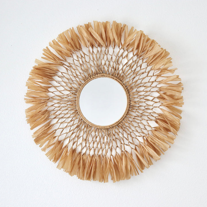 Handcrafted macrame raffia fiber art mirror by Yashi Designs, a blend of rustic modern aesthetics for unique wall decoration.