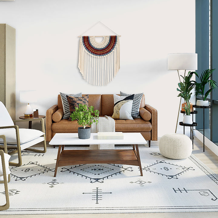 Modern living room with a brown sofa, coffee table, and decorative elements.