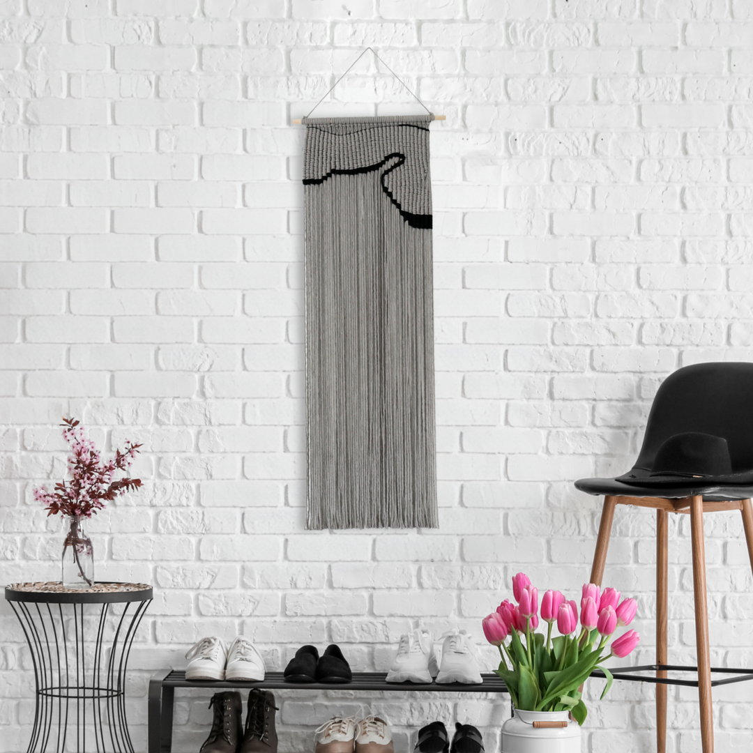 Contemporary gray macrame wall hanging with a nunique and modern black design, creating a modern and artistic statement in any space or interior 