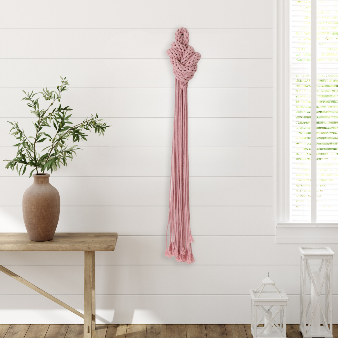 Pink hand knotted art with fringe, made from cotton rope braiding showcasing artwork in modern organic interiors.