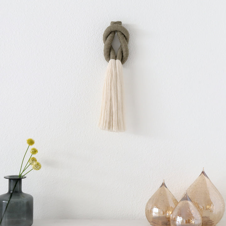 small jrope sculpture sculpture placed on a white mantel, adding texture and warmth to the decor