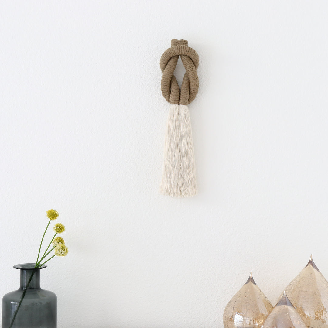 small jute and cotton rope sculpture placed on a white mantel, adding texture and warmth to the decor.