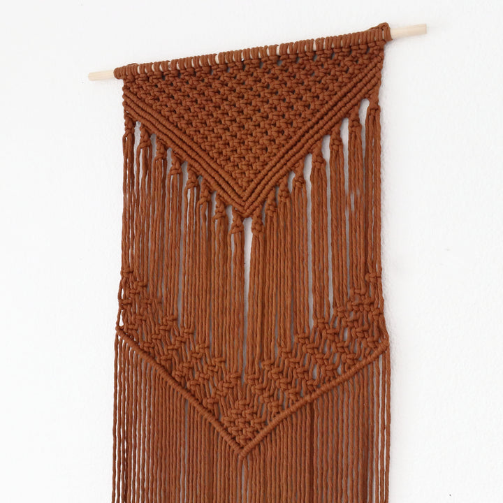 Rust color macrame wall hanging close up