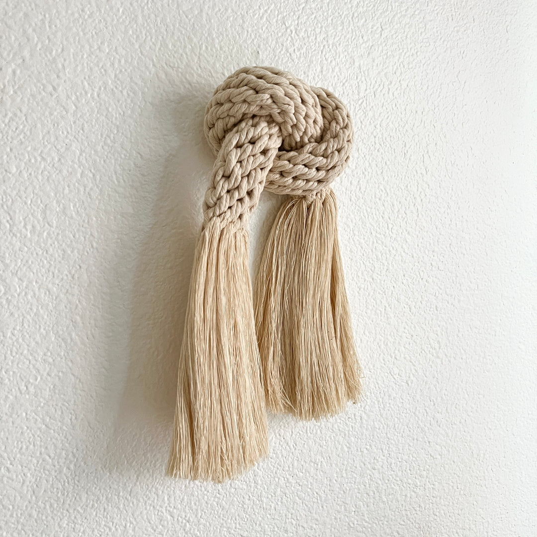 Minimalist fiber art featuring a classic knot design.