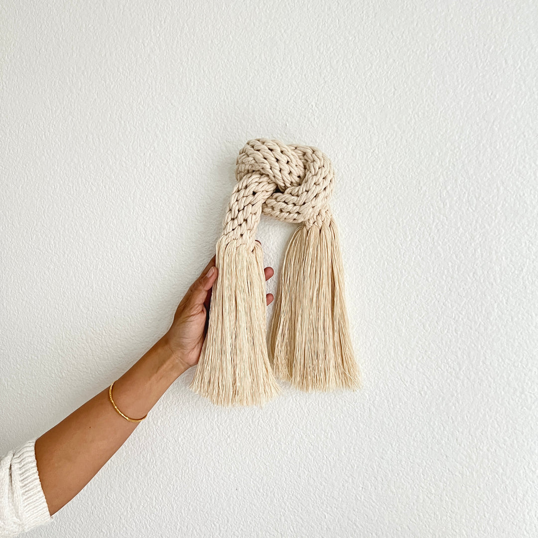 Minimalist fiber art featuring a classic knot design.