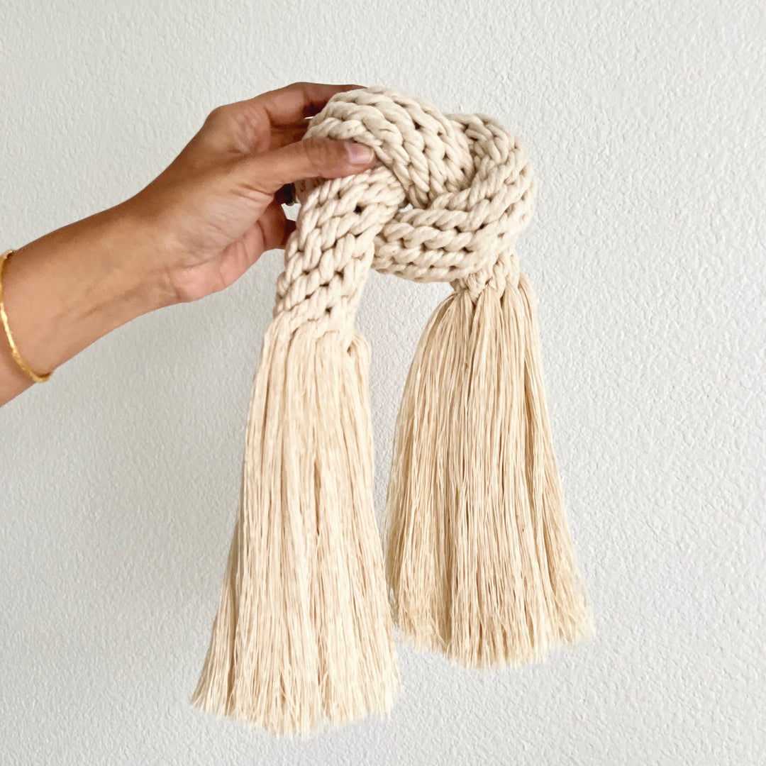 Minimalist fiber art featuring a classic knot design.