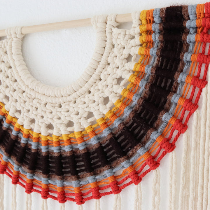 Macrame wall hanging with multicolored yarn on a white background