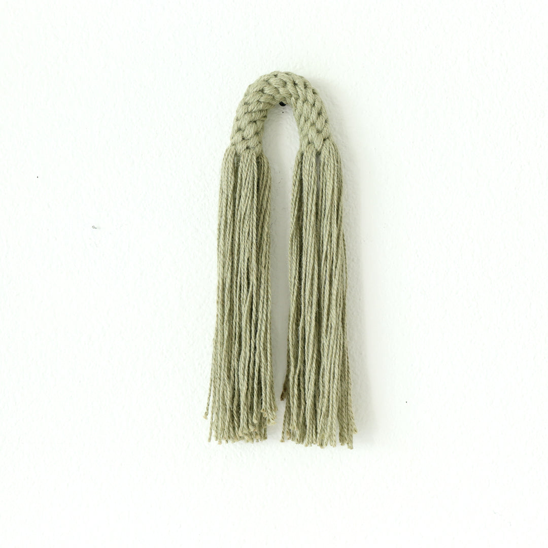 Small hemp tassel in sage green, a handcrafted Natural Dimensional Wall Art by Yashi Designs, minimalistic and modern wall hanging.