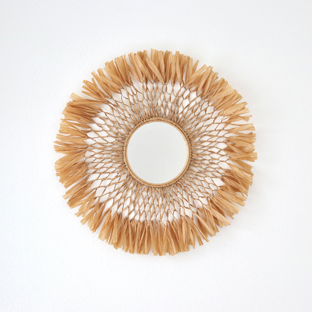 Handcrafted macrame raffia fiber art mirror by Yashi Designs, a blend of rustic modern aesthetics for unique wall decoration.