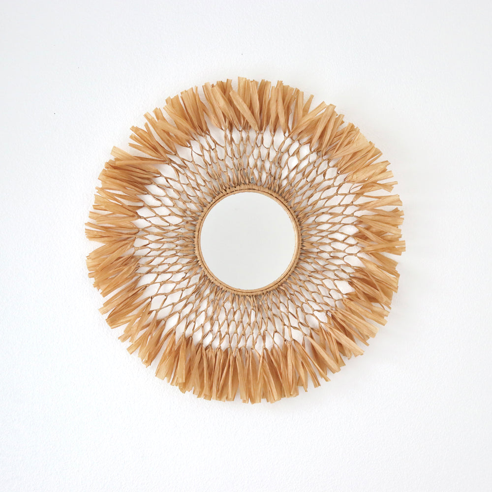 Handcrafted macrame raffia fiber art mirror by Yashi Designs, a blend of rustic modern aesthetics for unique wall decoration.